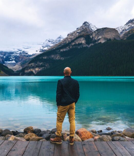 Traveller looking at Lake Louise and the Rocky Mountains