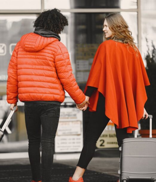Couple holding hands with luggage at an airport